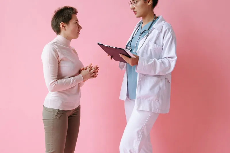 Médica conversando com uma paciente no consultório